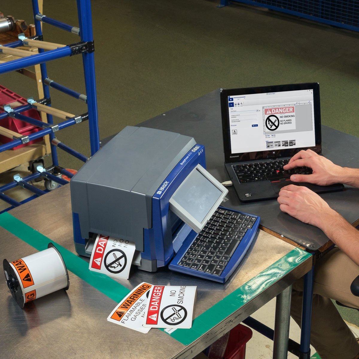 Technician using a Brady S3100 label printer to create lockout/tagout (LOTO) tags at a facility maintenance workstation