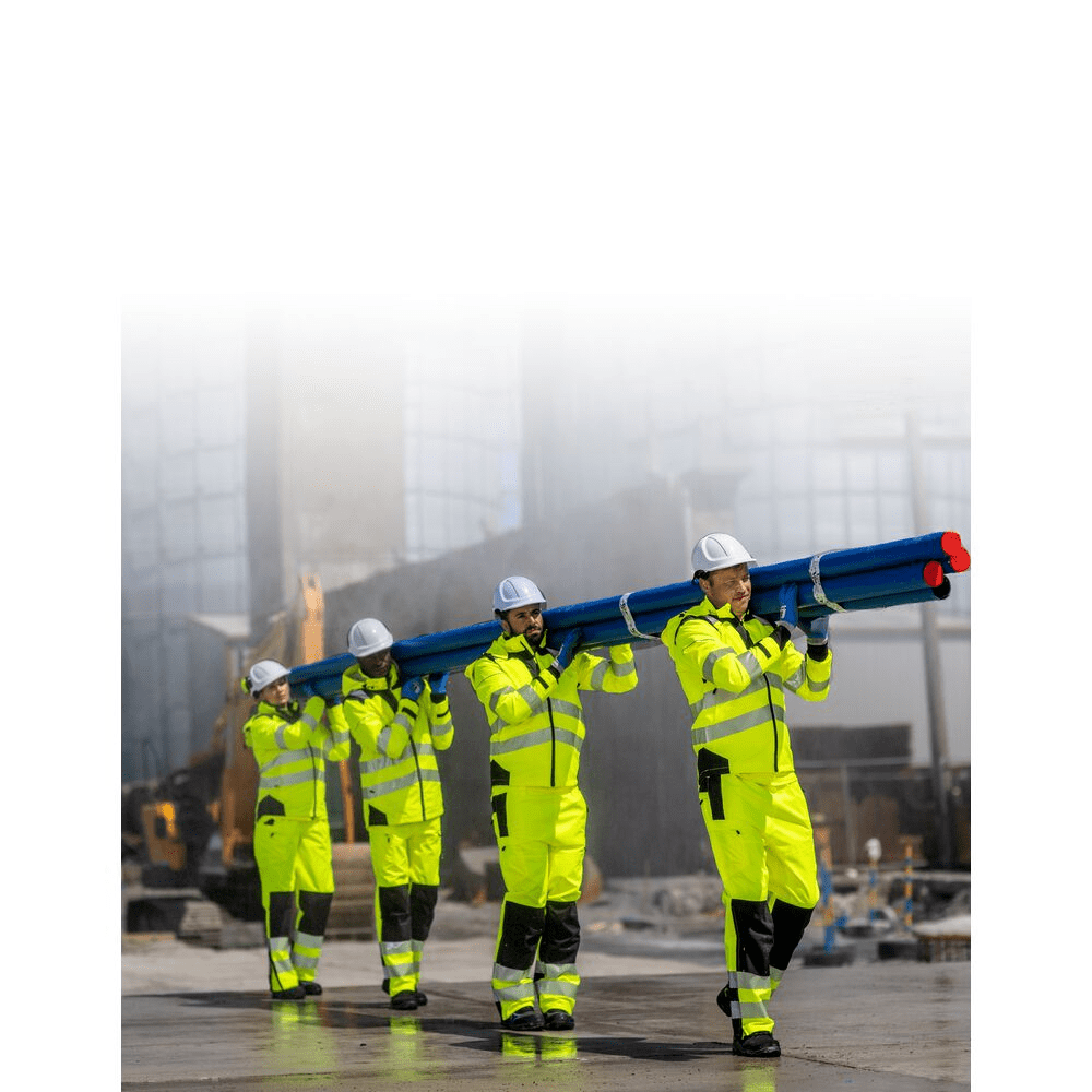 Worker wearing lemon Coveralls with reflective tape across the chest, back, and sleeves, standing outdoors